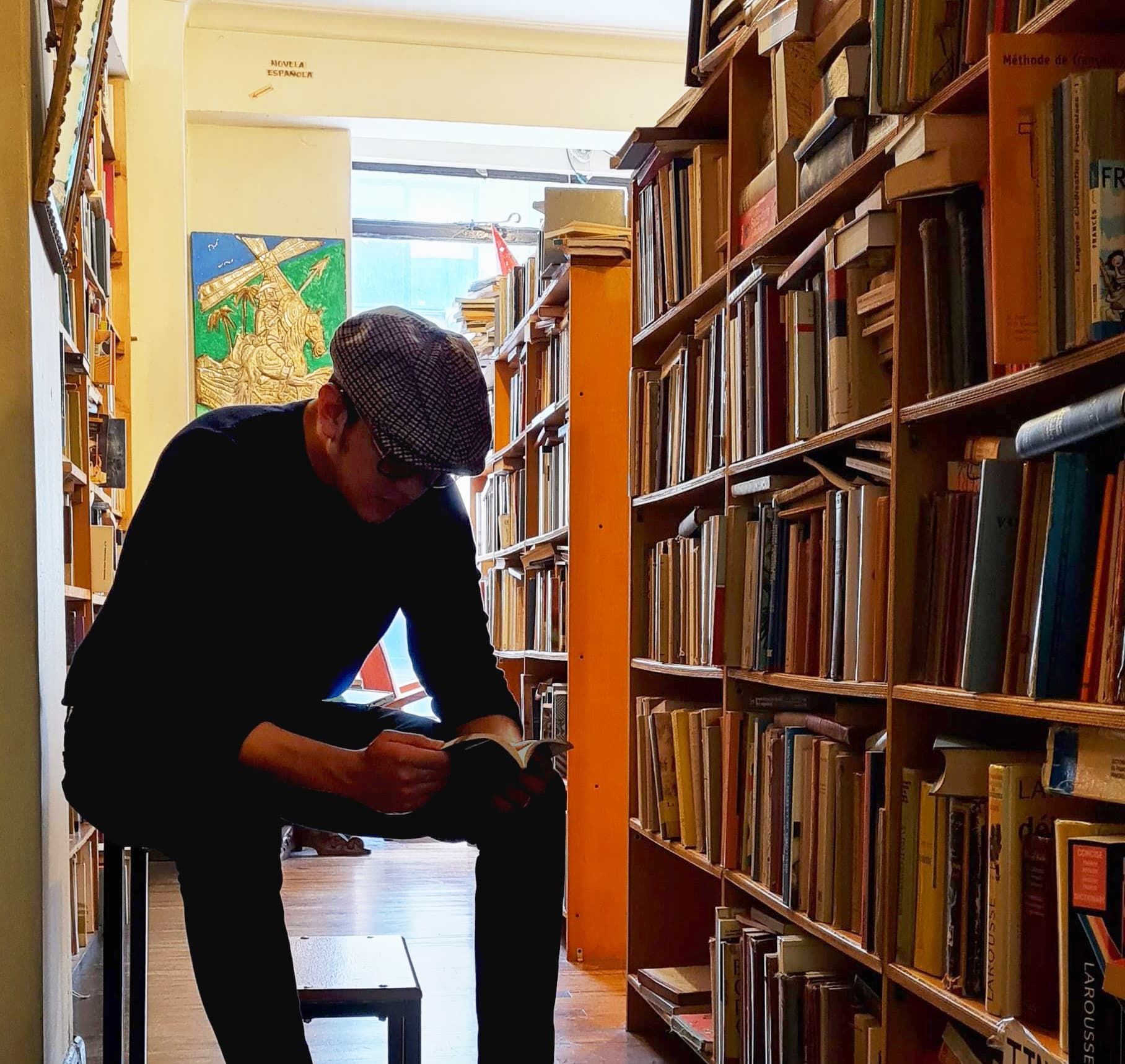 Dr Willima Guerrero foto leyendo libro en libreria sentado